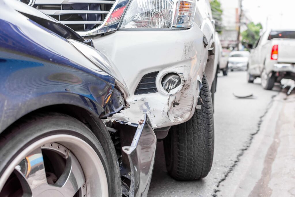white and blue car crash involving front bumpers